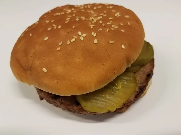 Hambúrguer com picles e pão na mesa branca — Fotografia de Stock