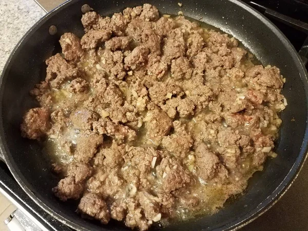 Carne moída cozinhar na frigideira no fogão com alho — Fotografia de Stock