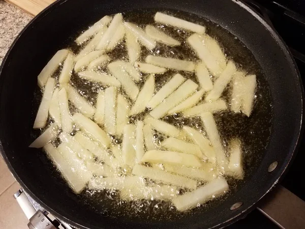 Картофель фри приготовление в масле на сковороде на плите — стоковое фото