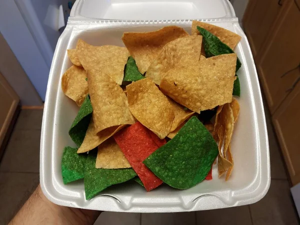 Trzymanie prostych, czerwonych i zielonych chipsów tortilla — Zdjęcie stockowe