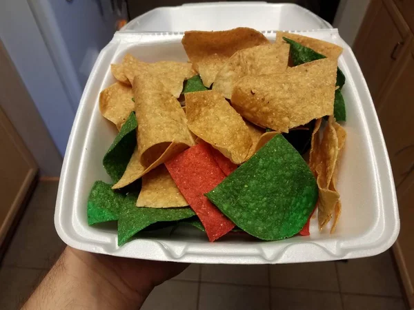 El ele tutuşurken sade, kırmızı ve yeşil tortilla cipsi — Stok fotoğraf