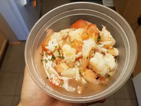 Holding shrimp and tomato in plastic container — Stock Photo, Image