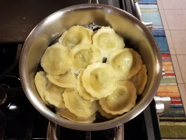 Ραβιόλια ζυμαρικά μαγείρεμα στο νερό σε κατσαρόλα στο φούρνο — Φωτογραφία Αρχείου