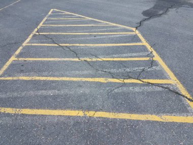 Otoparkta asfalt üzerinde sarı çizgiler.