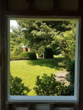 Bahçeye bakan yeşil çimenler, ağaçlar ve kırmızı tuğlalar