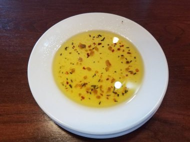 Zeytinyağı, sarımsak, otlar ve baharatlı beyaz tabak.