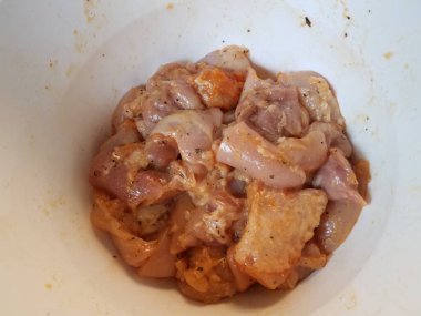 Çiğ tavuk ya da kümes hayvanlarıyla dolu beyaz plastik bir kase.