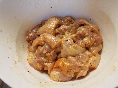 Çiğ tavuk ya da kümes hayvanlarıyla dolu beyaz plastik bir kase.