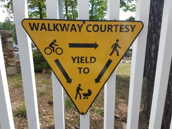 Yellow Sign White Fence Walkway Courtesy Yielding — Stock Photo, Image