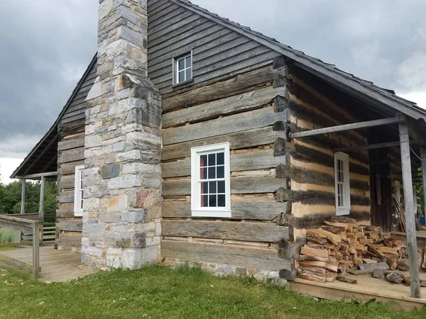 wooden building or cabin with firewood and stone chimney