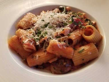 Beyaz kasede sebzeli ve peynirli İtalyan makarnası.