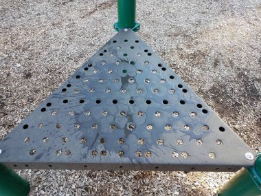 ıslak kahverengi metal oyun alanı üçgen yüzeyi delikleri ve su ile