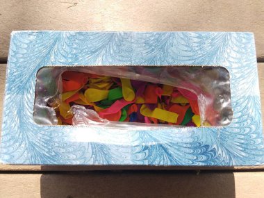 Bir sürü renkli su balonuyla dolu bir mendil kutusu.