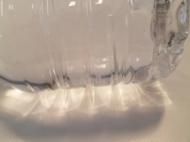 Beyaz yüzeyde küçük plastik bir su şişesi.