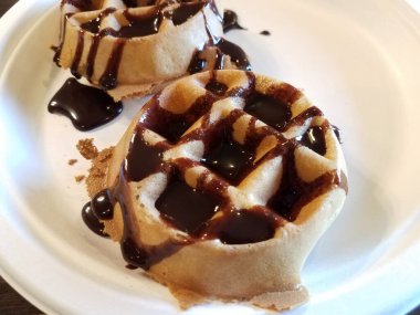 Beyaz tabakta waffle üzerine çikolata şurubu.