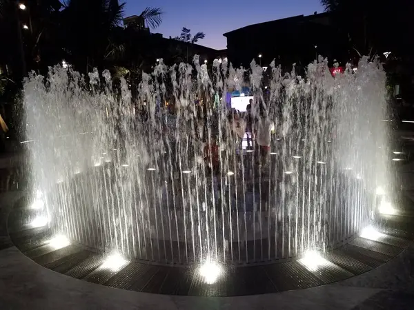 Pessoas Brincando Jatos Fonte Água Com Luzes Noite Livre — Fotografia de Stock