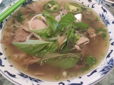 Biftek, fesleğen ve soğanlı bir kase Vietnam çorbası.