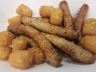 Beyaz kabın içinde patates kroketli hindi sosisi halkaları