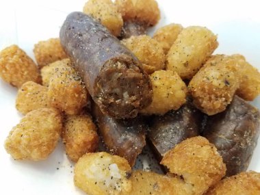 Beyaz kabın içinde patates kroketli hindi sosisi yığını.