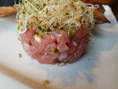 Beyaz tabakta lahanalı çiğ ton balığı.