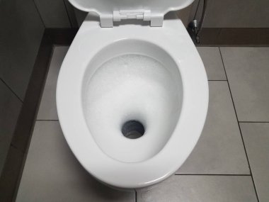 Tuvalette ya da banyoda köpüklü beyaz tuvalet ve fayanslar