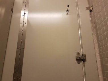 Gri bir tuvalet kapısı kilitli.