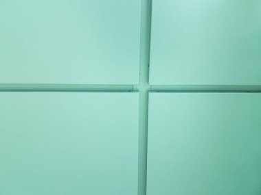 Duvarda çizgileri olan mavi karolar var.