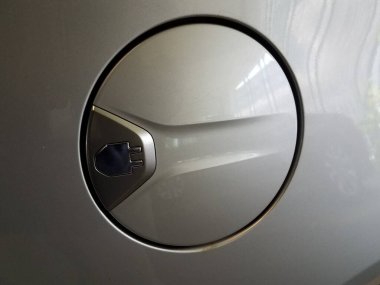 Üzerinde elektrik prizi logosu olan gümüş arabanın benzin deposu kapısı.