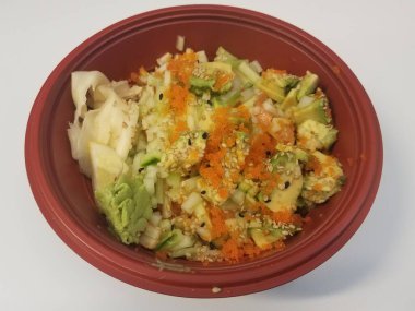 İçinde balık, balık yumurtası, avokado ve pirinç olan kırmızı bir kase.