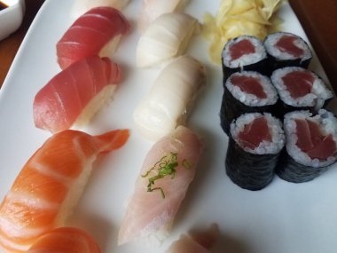 Somon balığı ve çiğ deniz ürünleri suşisi tabakta pilav ve yosun.