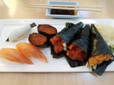 kalamar, somon, somon yumurtası ve beyaz tabakta suşi.