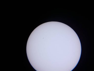 Güneş ve güneş lekeleri amatör bir teleskopta bir güneş filtresinden görülüyor.