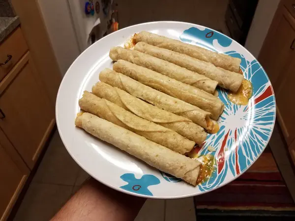 Hand Hält Heißen Tacitos Auf Teller Der Küche — Stockfoto