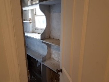 Penceresi ve kirli eski rafları olan bir depo.