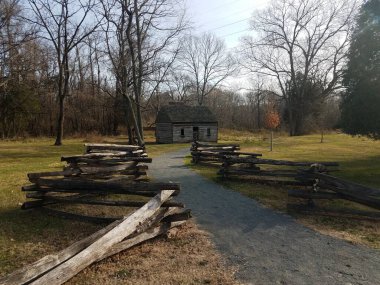 Tahta çitli taş ya da çakıl patikası ve eski ahşap kulübe