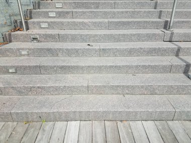 Gri çimento basamakları, ışıklar ve kahverengi tahtalar.