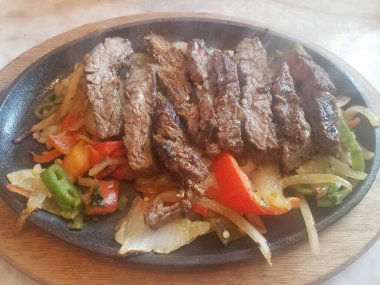 Bir tabak sığır eti, soğan, biber ve duman.