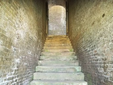 Çok eski merdivenler ve tortulu kırmızı tuğla duvar.