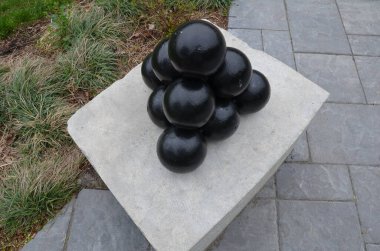 Çimento bloğunda çimento ve gri kiremitli siyah gülleler yığını