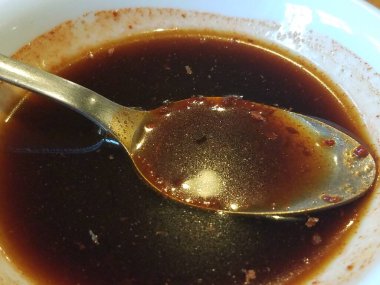 Baharatlı soya sosunda metal bir kaşık.