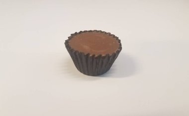 Beyaz yüzeye sarılı küçük kahverengi çikolata şekeri.