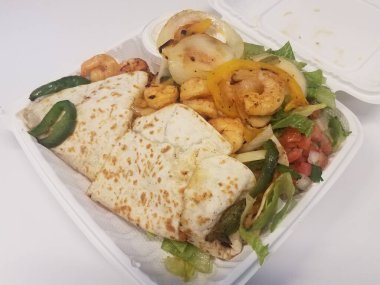 Karides, soğan, domates, marul ve biberli tortilla.
