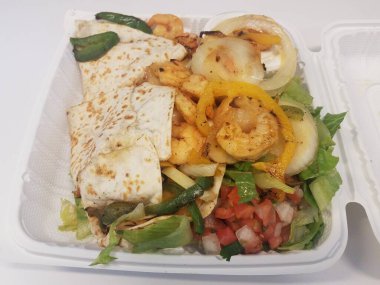 Karides, soğan, domates, marul ve biberli tortilla.