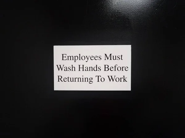 白い従業員は黒いドアや壁の標識に戻る前に手を洗う必要があります — ストック写真