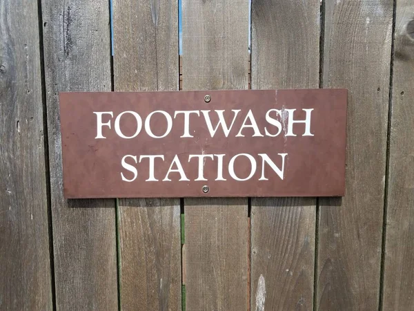 茶色の木製の柵の上の足洗い場の標識 — ストック写真