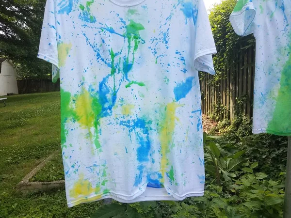 白いシャツにペンキがかかって裏庭で乾く — ストック写真