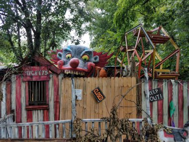 Çitin üzerinden korkunç palyaço geçen eski bir kapatma eğlence evi.