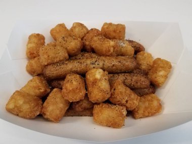 Hindi sosisi ve patates, tuzlu ve biberli beyaz kabın içinde.