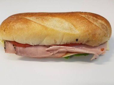 Beyaz masa ya da yüzeyde domatesli, ekmekli ve salamlı sandviç