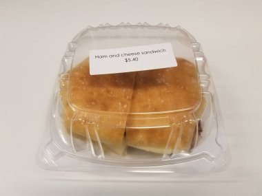 jambonlu ve peynirli plastik kutu üzerinde etiket ve beyaz yüzey veya masa etiketi var.